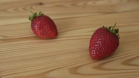 Strawberries in a small basket on the wooden table - close up. Stock Footage 80361809