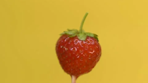 Strawberries spinning on a yellow background Stock Footage 134444772