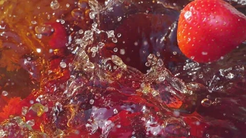 Strawberries splashing into tea with bubbles in slow motion 300fps Stock Footage 287698723