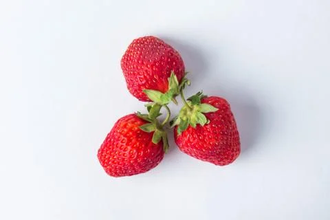 Strawberries on a white background. Three red, ripe and juicy strawberries.  Stock Photos