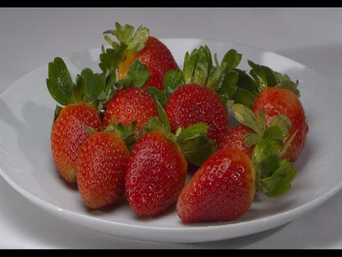 Strawberries on a white plate being sprayed with water, slow motion Stock Footage 74203410