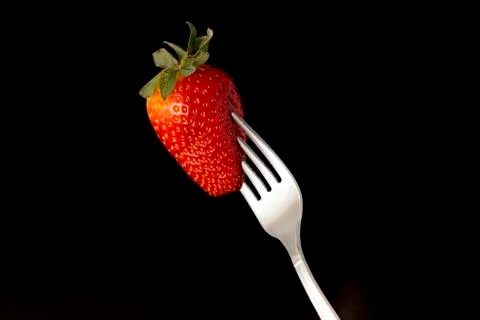 Strawberry and fork Stock Photos