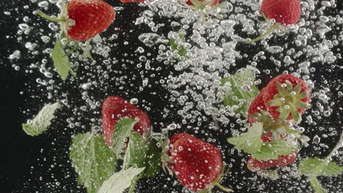 Strawberry beautiful falling into water in slow motion on black background Stock Footage