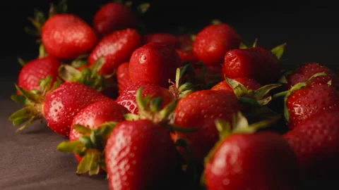 Strawberry on black background slow mo side view Stock Footage