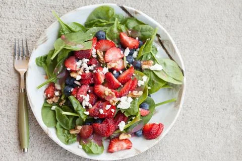 Strawberry blueberry walnut spinach salad full top view with fork Stock Photos