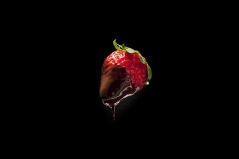 Strawberry in chocolate on black isolate Stock Photos