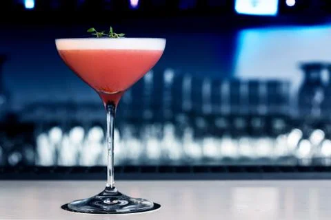 Strawberry cocktail on the bar counter. With background in shades of blue and Stock Photos