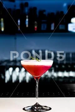 Strawberry cocktail on the bar counter. With background in shades of blue and Stock Photos
