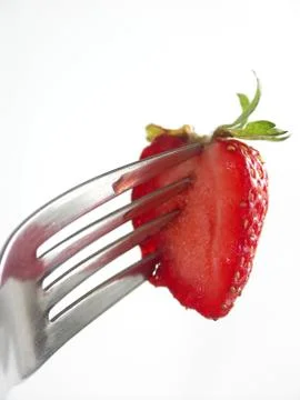 Strawberry colopuncture on fork on white background Stock Photos