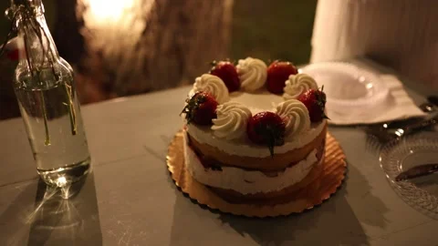 Strawberry cream cake on table at evening celebration Stock Footage 337728969