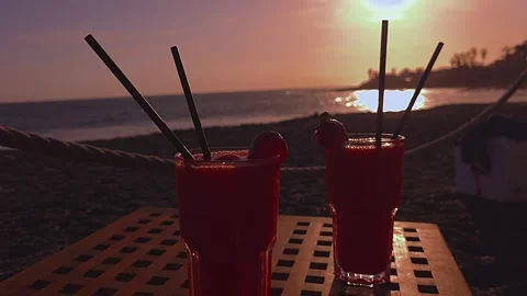Strawberry Daiquiris on Beach Table at Sunset with Ocean View Stock Footage 346480201