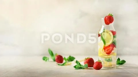 Strawberry detox water with mint, lemon on grey background. Citrus lemonade Stock Photos