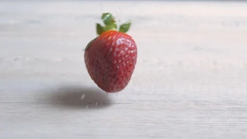 A strawberry dropping down on the table, fruits falling on the ground, sweets Video stock 96995208