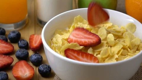Strawberry falling in to corn flakes splashing in slow motion. Stock Footage 94715305