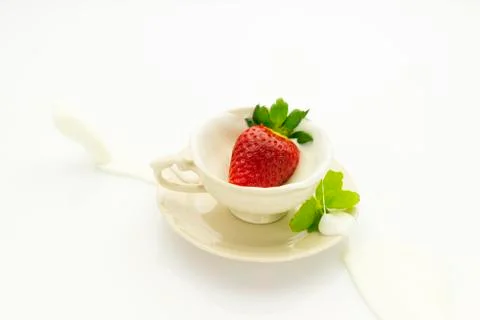 Strawberry falling into cream Stock Photos