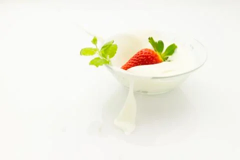 Strawberry falling into cream Stock Photos