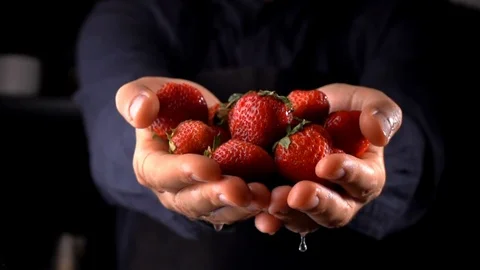 Strawberry falling from man's hand on dark background 動画素材 116495751