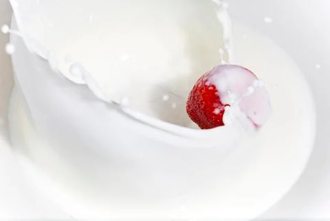The strawberry falling in milk Foto stock