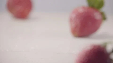 Strawberry falls down on heap of fresh berries with water drops slow motion Video stock 127614431