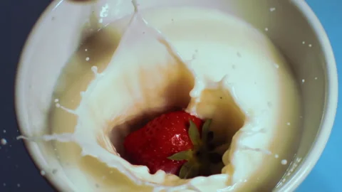 Strawberry falls slowly into the milk Stock Footage 274263745