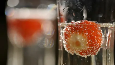 Strawberry floating in sparkling wine (close up) (slowmo) Stock Footage 162689726