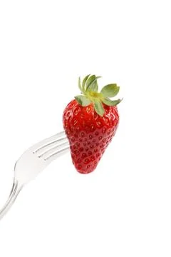 Strawberry on a fork isolated on white background. Stock Photos