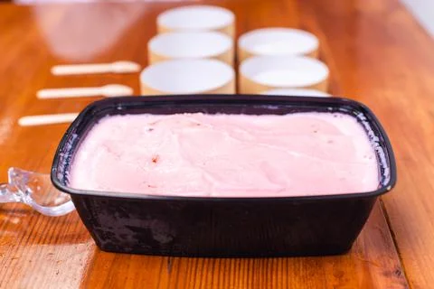 Strawberry ice cream with packaging on table Stock Photos
