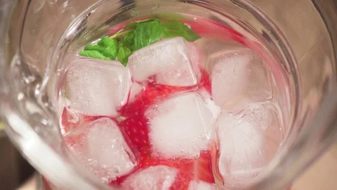 Strawberry with ice in the decanter and the camera moves down on the strawberry Stock Footage 90419982