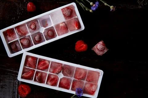 Strawberry ice in the forms. Preparing summer ice for cocktail, ice-cream and Stock Photos
