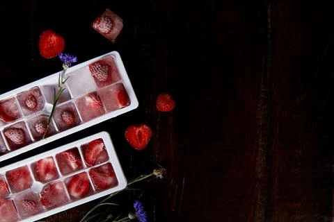 Strawberry ice in the forms. Preparing summer ice for party cocktails, ice-cream Stock Photos
