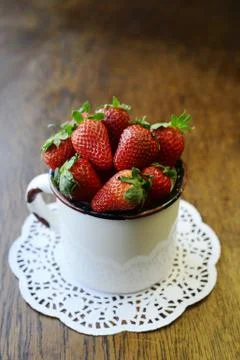 Strawberry in a mug on a wooden table Stock Photos