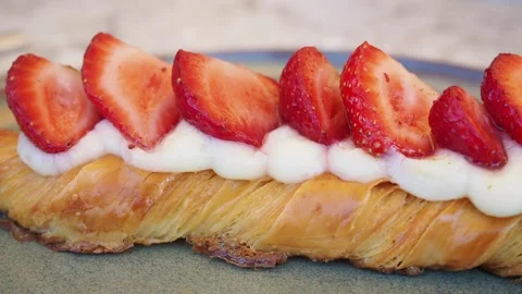 Strawberry pastry is displayed on a plate at a local cafe Stock Footage 347039082