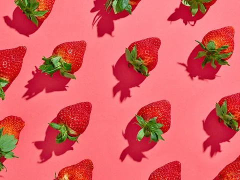 Strawberry pattern on pink background, from above, hard shadow Stock Photos