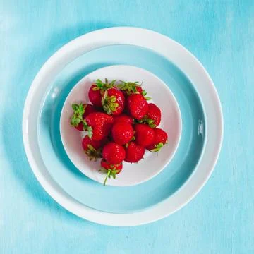Strawberry in plate on blue background, top view 库存照片