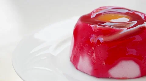 Strawberry pudding with orange jam on top, rotating in a white plate Stock-Footage 54340141