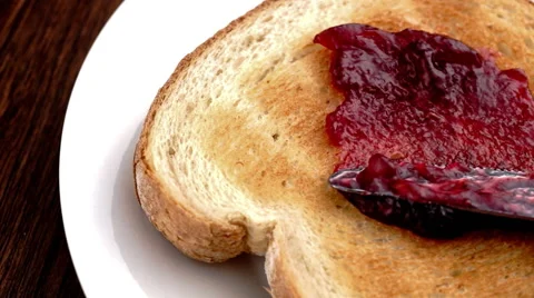 Strawberry raspberry jam being spread on toast in slow motion Video stock 46882805
