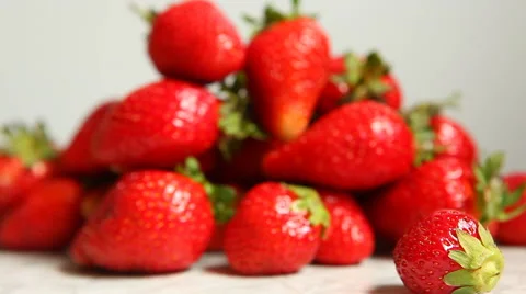 Strawberry rolls in front of blurred background with handful of berries Stock Footage 63223612