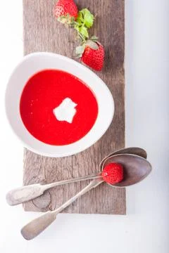 Strawberry soup with a spoon on a table. Stock Photos