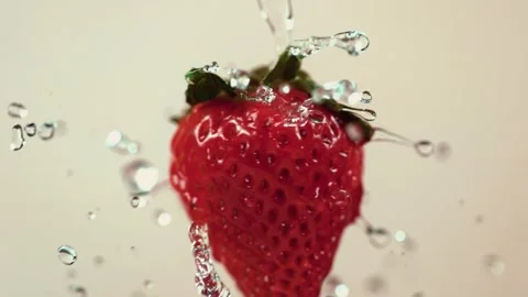 Strawberry splash close up motion of fresh water washing fruit Stock Footage 327573580