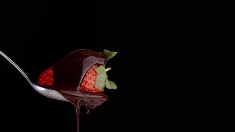 Strawberry in the spoon on black background, covered by chocolate. Stock Footage 150117137