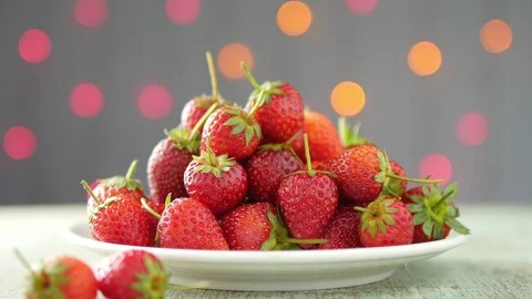 Strawberry stack in white dish over colorful blink light bokeh background Video stock 101001592