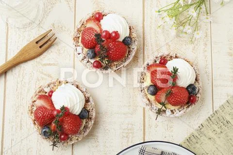 Strawberry tartlets with blueberries, redcurrants and cream (seen from above) Stock Photos