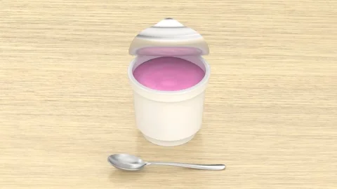 Strawberry yogurt container and silver spoon Stock Footage 346033133