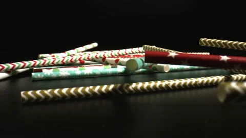 Straws for drinking, disposable biodegradable cocktail straws rolling on a black Video stock 144342555