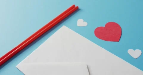 Straws with paper hearts and envelope on blue background at valentine's day Stock Footage 340007732