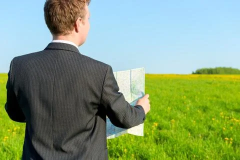 Strayed man seeking to map the way in the field Stock Photos
