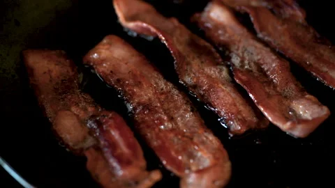 Streaky bacon rashers frying in a cast iron skillet 動画素材 132506138