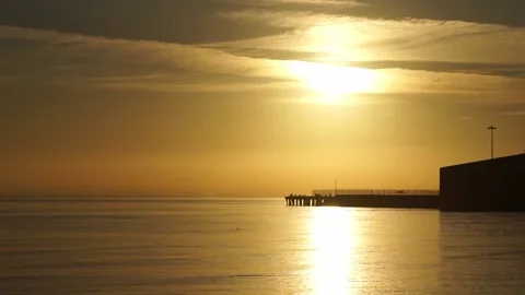 Streaky clouds over pier during sunrise in San Francisco Bay Stockbeeldmateriaal 233902755