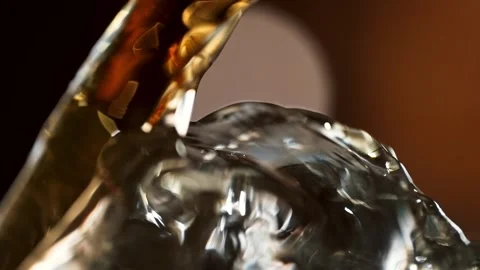 Stream of Amber Whisky Flowing Smoothly over an Ice Cube in Macro &amp; Slow Motion Stock Footage 271007358