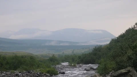 Stream and big mountain covered by fog on the background. Ural mountains Stock Footage 269565052